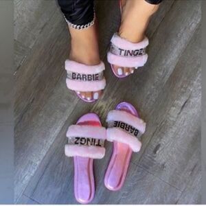 Stylish pink slides with 'Barbie' and 'Tingz' text. Fuzzy straps for comfort.